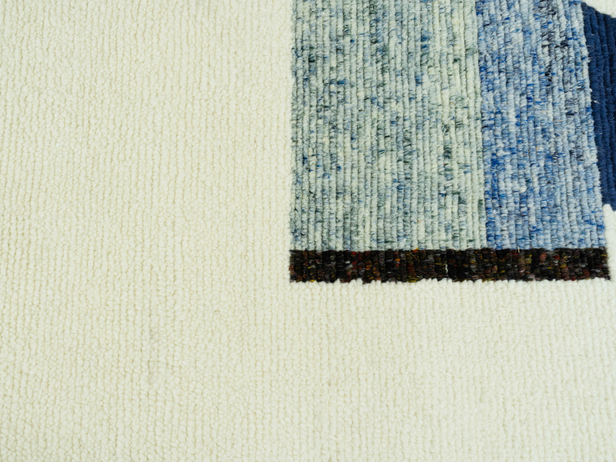 Nahaufnahme der Teppichkante mit blauem Musterstreifen und schwarzem Abschluss