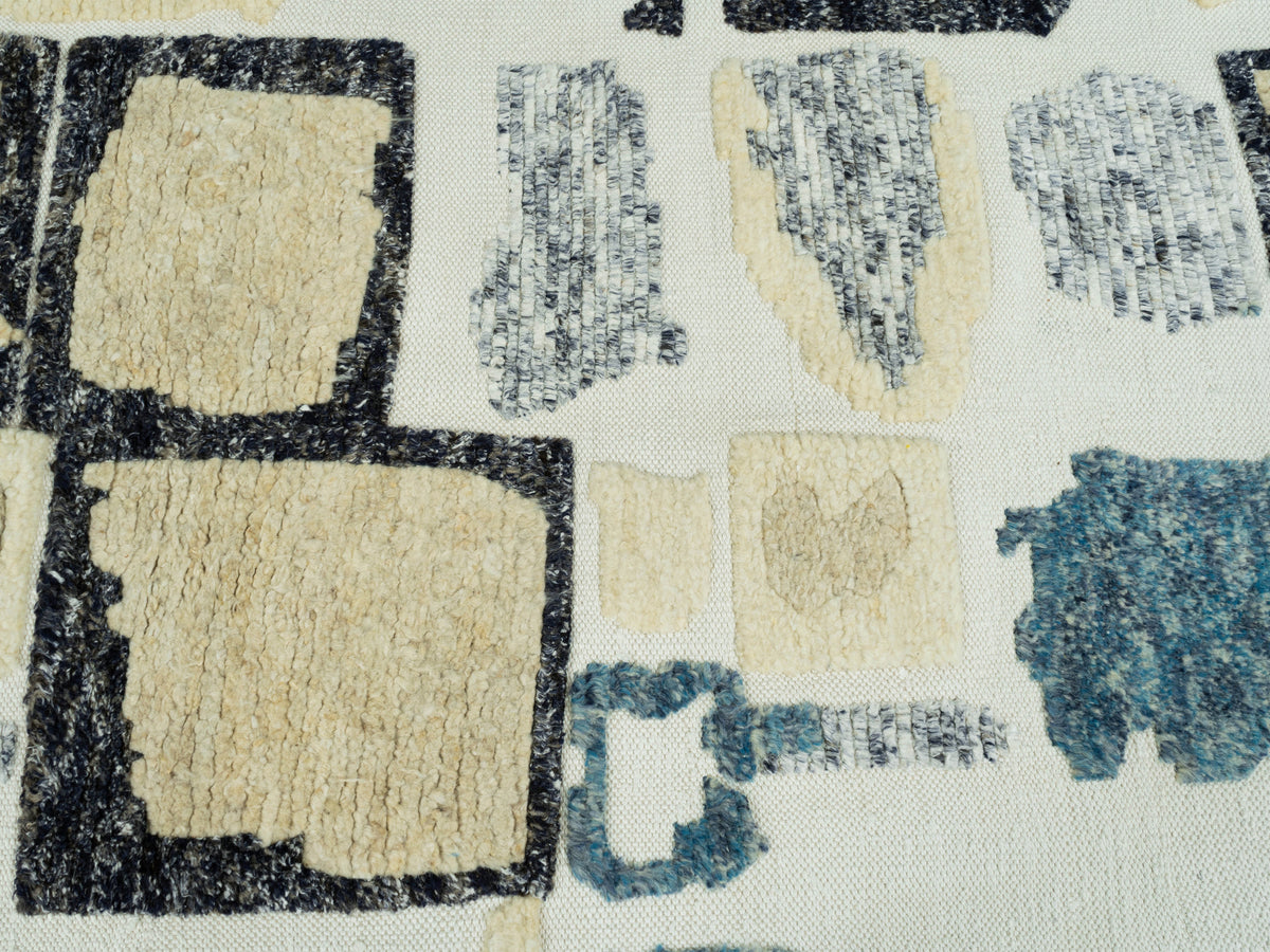Teppich 240x170 cm Nahansicht: quadratische Musterblöcke, creme Grund, blau-schwarze Akzente