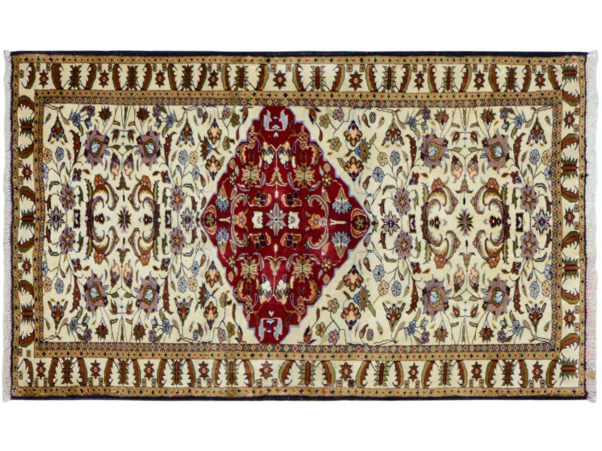 Tapis baloutche à larges bordures, médaillon rouge sur fond crème
