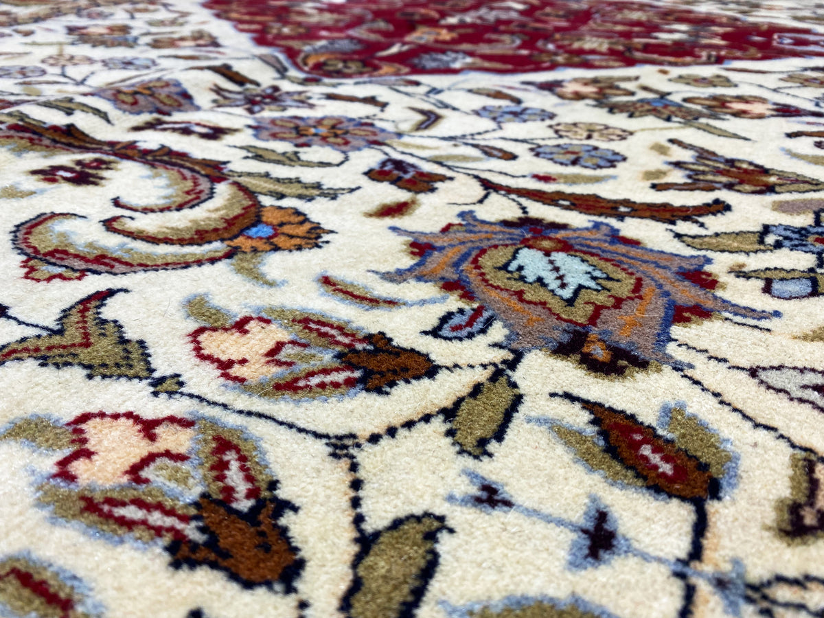 Détail d’un tapis baloutche, motifs en crème, rouge et bleu