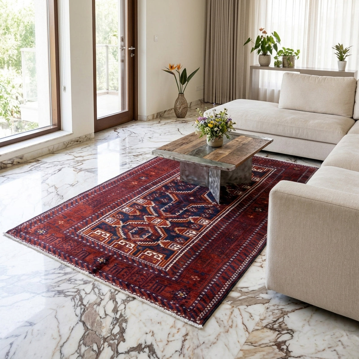 Tapis baloutche rectangulaire sur un sol clair, motif géométrique rouge et bleu avec bordure.