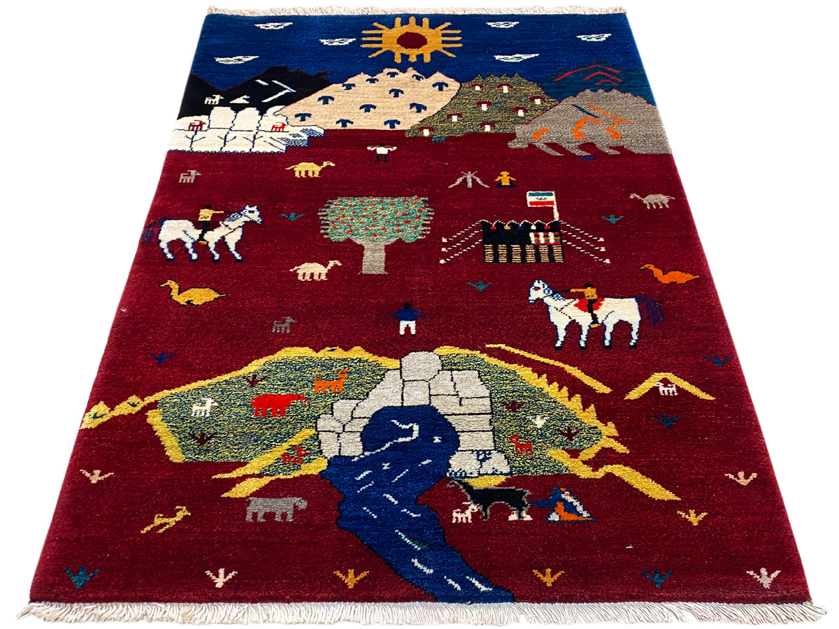 Tapis Gabbeh-Luri rouge et bleu avec représentations de paysages et d’animaux, franges