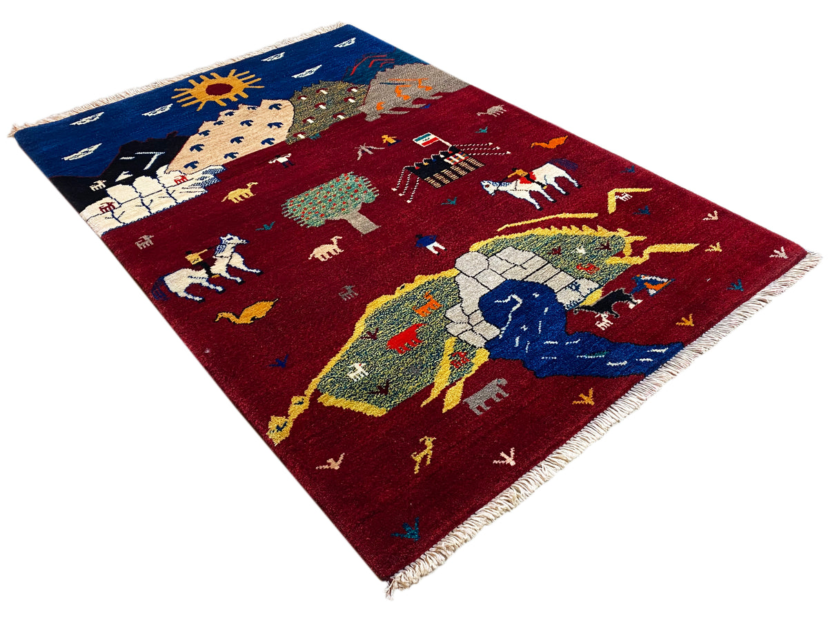 Tapis Gabbeh-Luri incliné, motif rouge avec soleil, cavaliers et animaux, franges