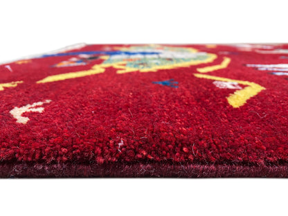 Détail de la surface du velours d’un tapis Gabbeh-Luri, champ rouge avec des lignes et des motifs jaunes