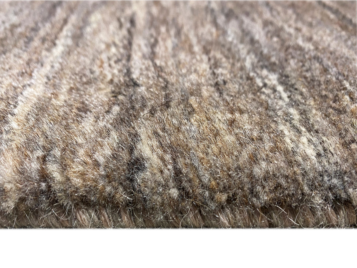 Nahaufnahme des Kurzflors: grau-beige Farben mit feinen goldenen Linien und leichtem Glanz.