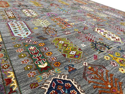 Nahaufnahme: grauer Teppich mit bunten Kreuz- und Rautenmustern im Feld.