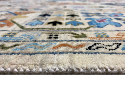 Nahansicht: Indo-afghanischer Teppich mit Flor und bunten Streifenornamenten am Rand