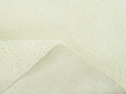 Teppichfläche in Detailansicht mit beiger, flauschiger Struktur und feiner Relieftextur