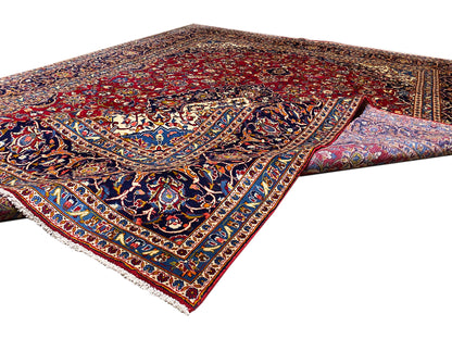 Orientteppich-Ecke mit rotem Grund, blauem Bordürenmuster und weißen Fransen