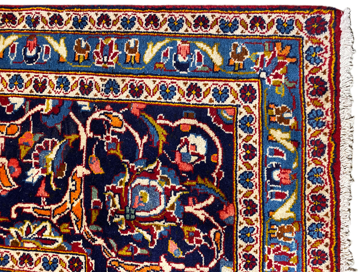Detail des Orientteppichs: bunte Motive, blau-rote Einfassung und helles Fransenende