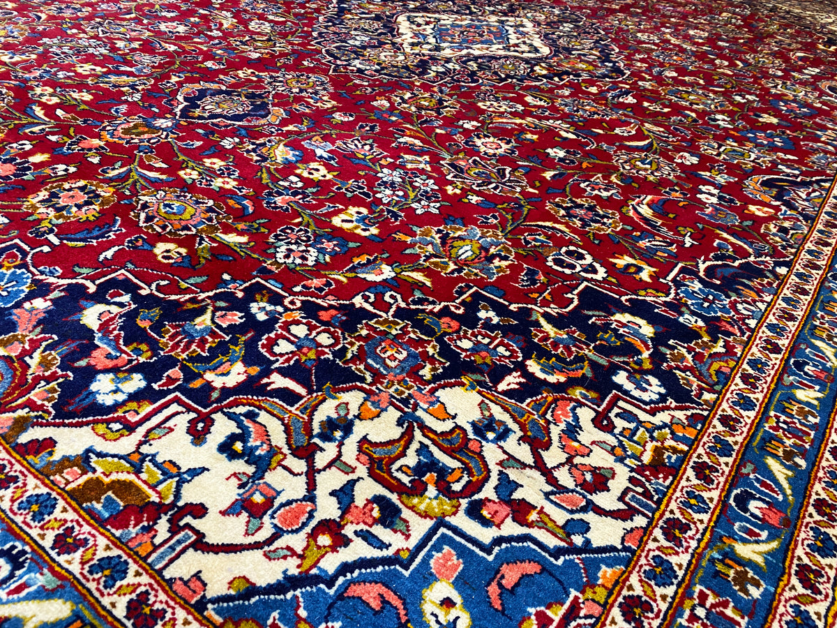 Nahaufnahme des Orientteppichs mit rotem Grund, blauem Rand und tierischen Ornamenten