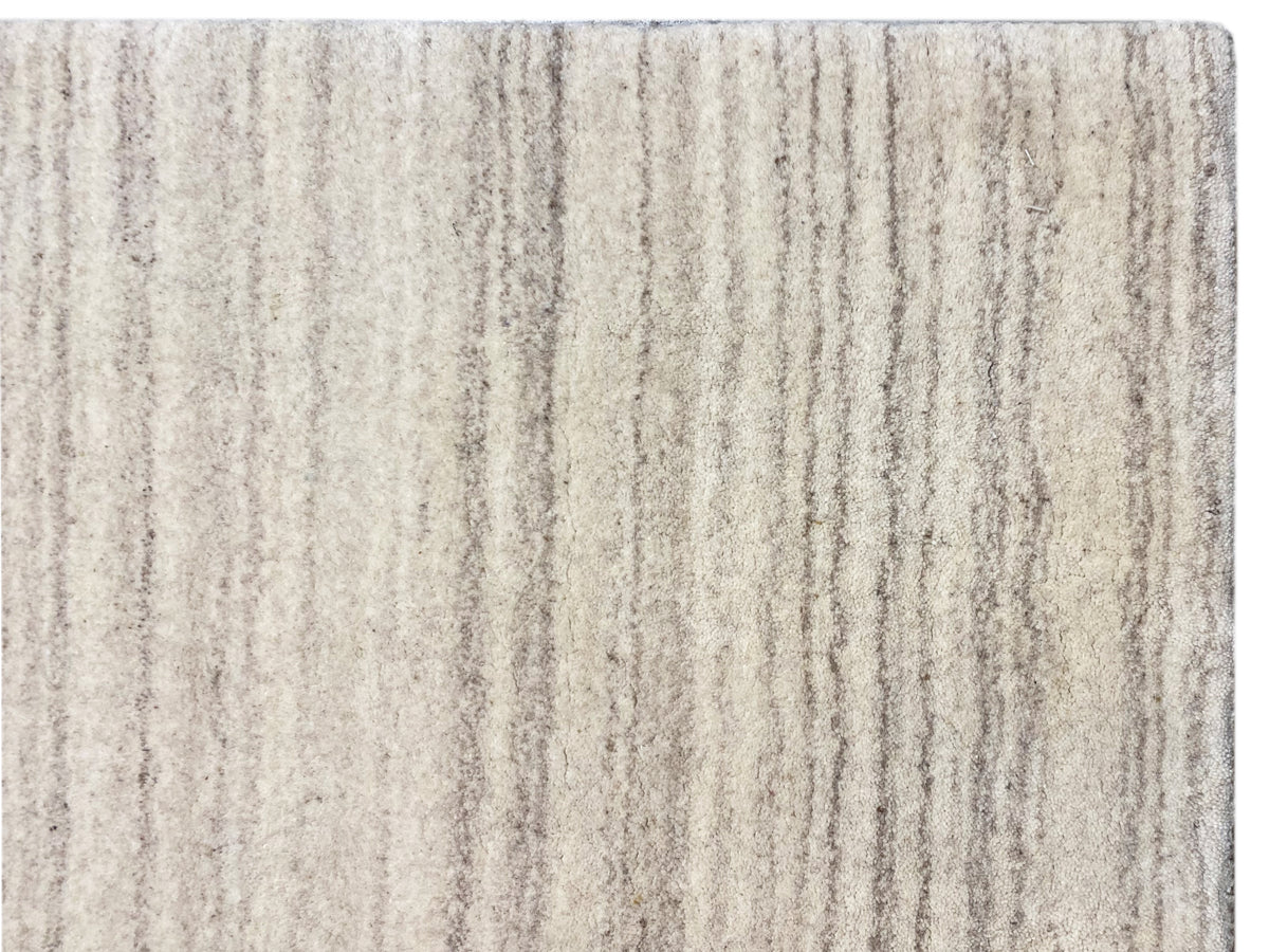 Nahaufnahme Gabbeh-Loom-Teppich: dichtes Streifenmuster in hellbeige und grauen Nuancen