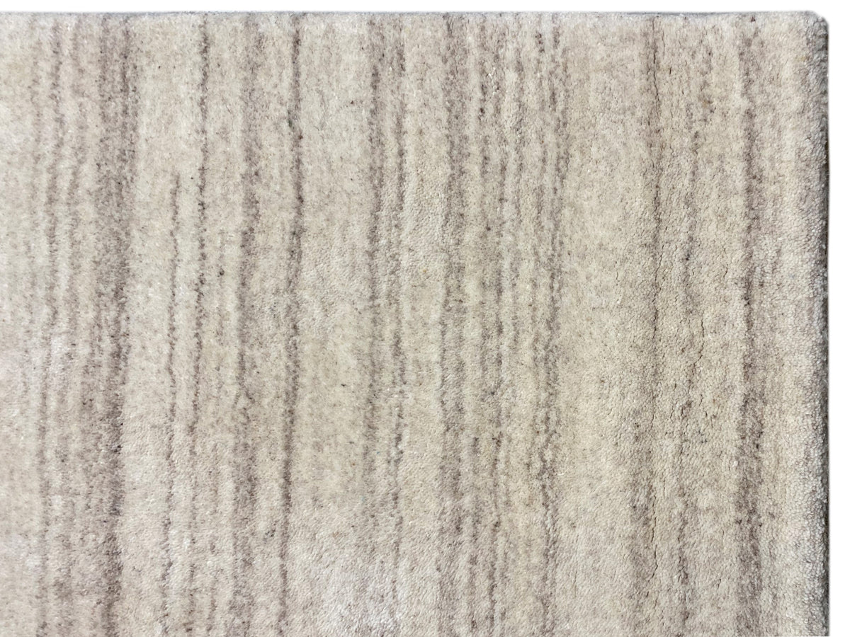 Nahaufnahme: Teppich mit beigem Flor und vertikalen, feinen Linien im Melange-Look
