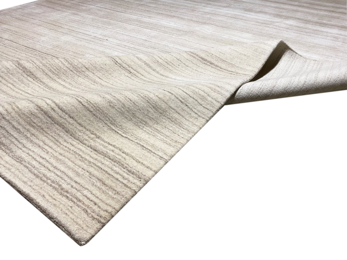 Gabbeh-Loom-Teppich mit sichtbarer Kante und zurückgeschlagenem Rand, hellbeige.