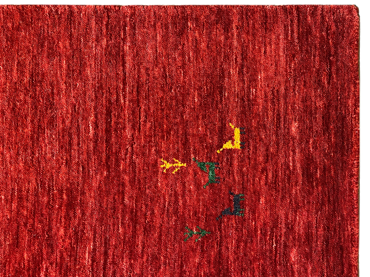 Loom Luri Teppich: roter Flor mit feiner, vertikaler Textur und kleinen farbigen Einsprengseln.