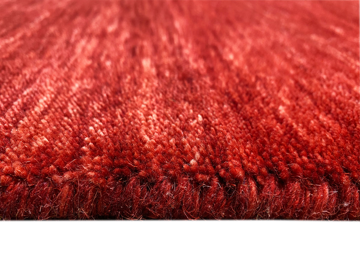 Loom Luri Teppich mit rotem Kurzflor, Detail der Faserstruktur am Rand.
