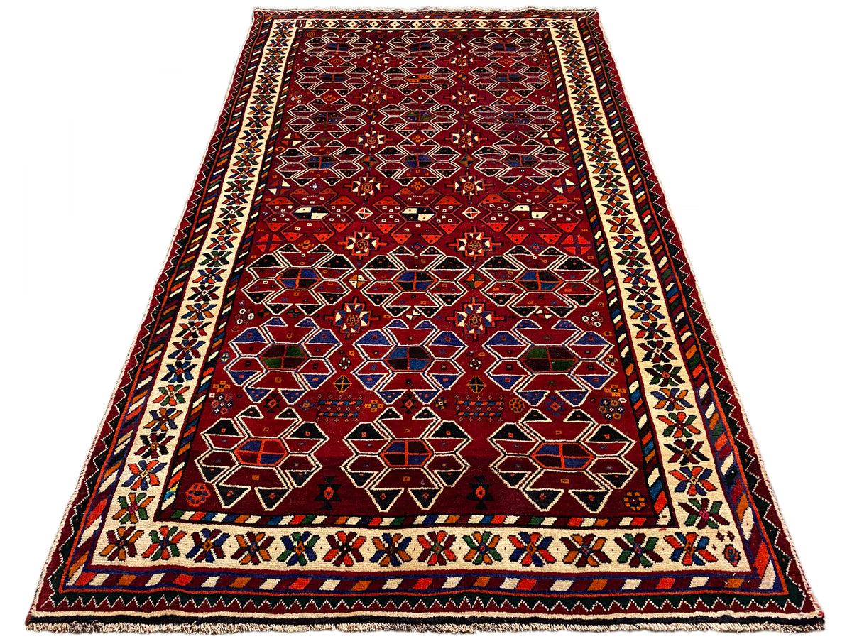 Orientteppich von oben: roter Grund, ornamentale Zierleisten und geometrische Felder