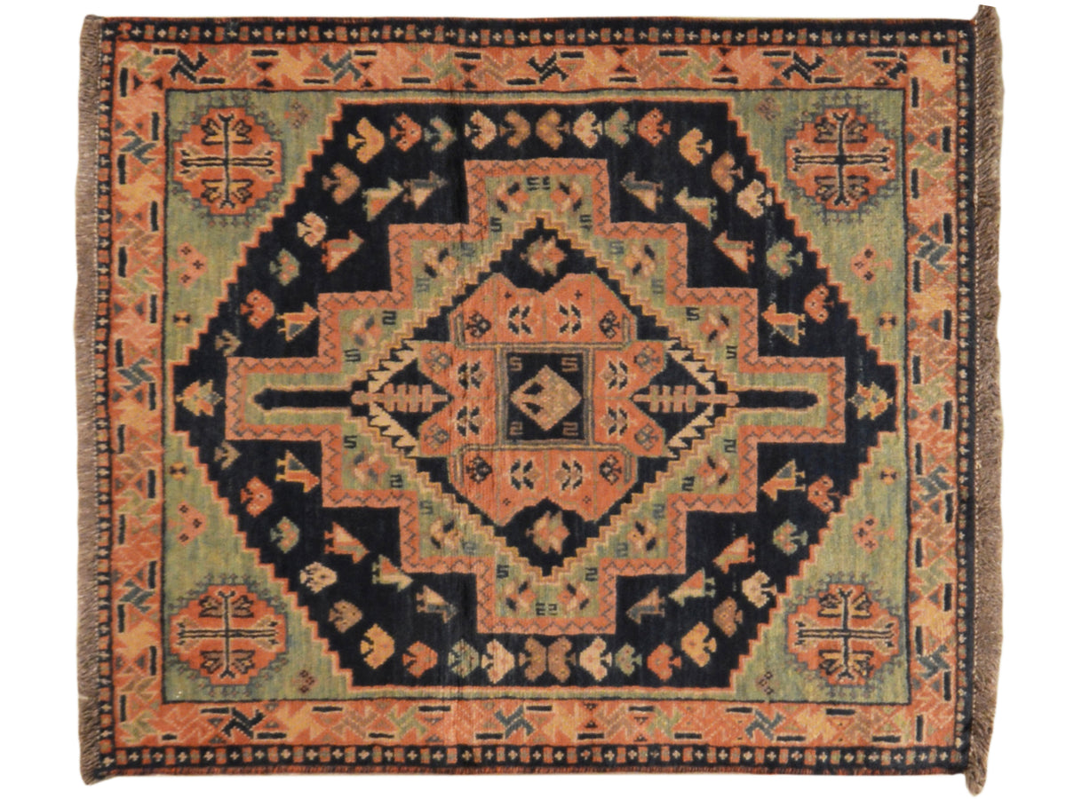 Teppich mit symmetrischem Medaillon und Rankenornamenten in Orange, Blau und Schwarz
